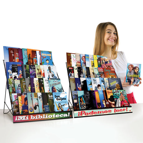  Student holding Spanish free voluntary reading book next to FVR library display with classroom reader collection.